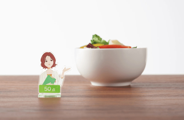 「あすけんの女」こと栄養士の未来さんがアクリルスタンドになってカプセルトイで登場。ご飯と一緒に撮って点数を捏造することもでき、もう彼女を泣かせなくて済む…かも(電ファミニコゲーマー)